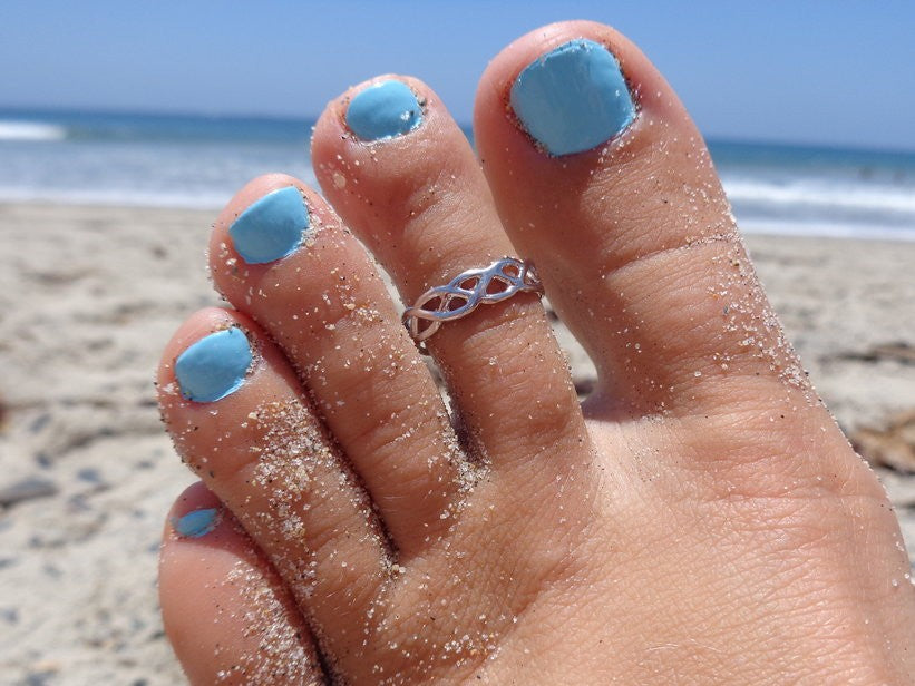 Celtic Weave Sterling Silver Toe Ring shown on a foot at the beach