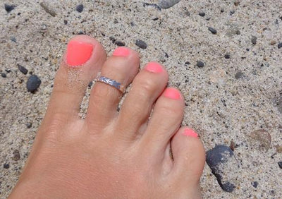 Hula Lei Sterling Toe Ring shown on a foot at the beach